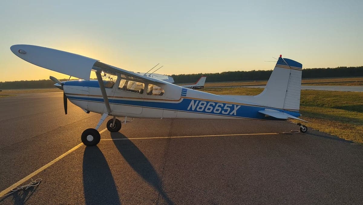 A Cessna 172 Skyhawk on the tarmac at sunset.