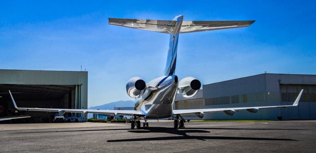 Rear view of a Bombardier Challenger 300 parked on the tarmac.