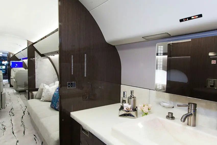 The interior of a private jet with a sink and countertop.