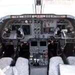 View of the aircraft cabin with leather seats and wood trim.