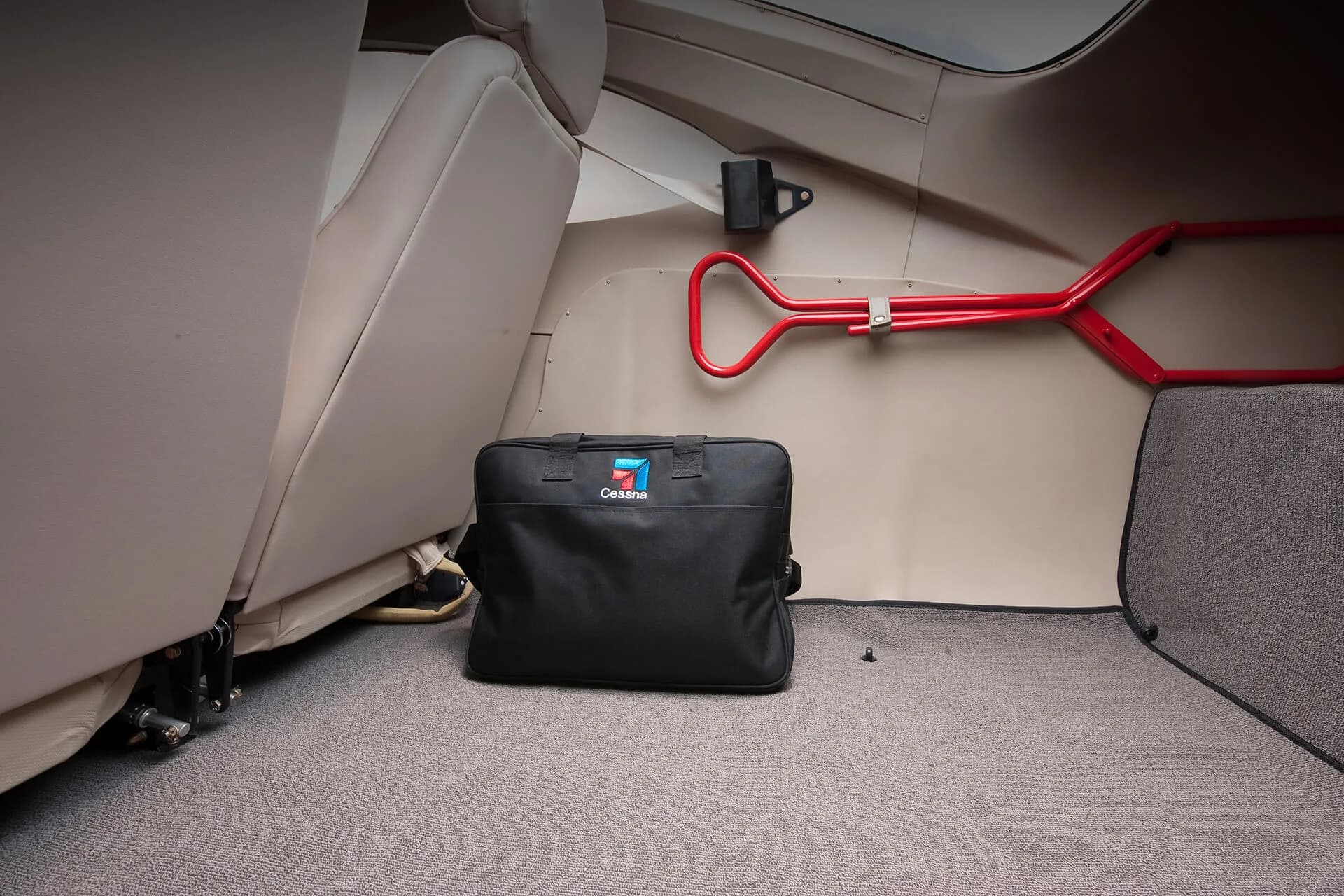 The rear cargo area of a Cessna 206 Stationair, featuring a Cessna-branded bag and emergency equipment.