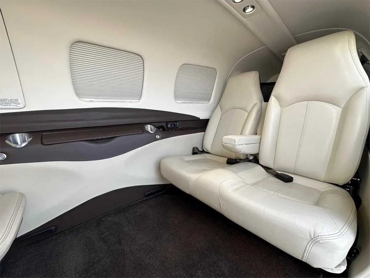 A view of the light-colored leather seats in the cabin interior of the Piper M350 aircraft.