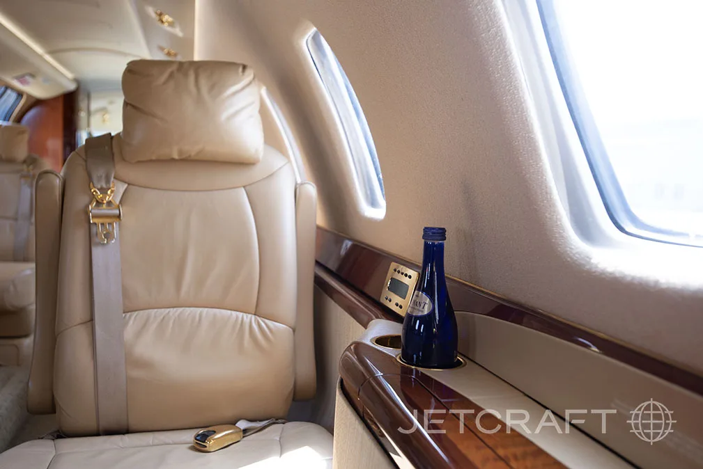 Close-up of a leather seat and side table in the jet's interior.