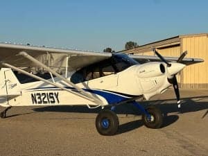 N321SY is a white and blue CubCrafters XCub parked on the tarmac.