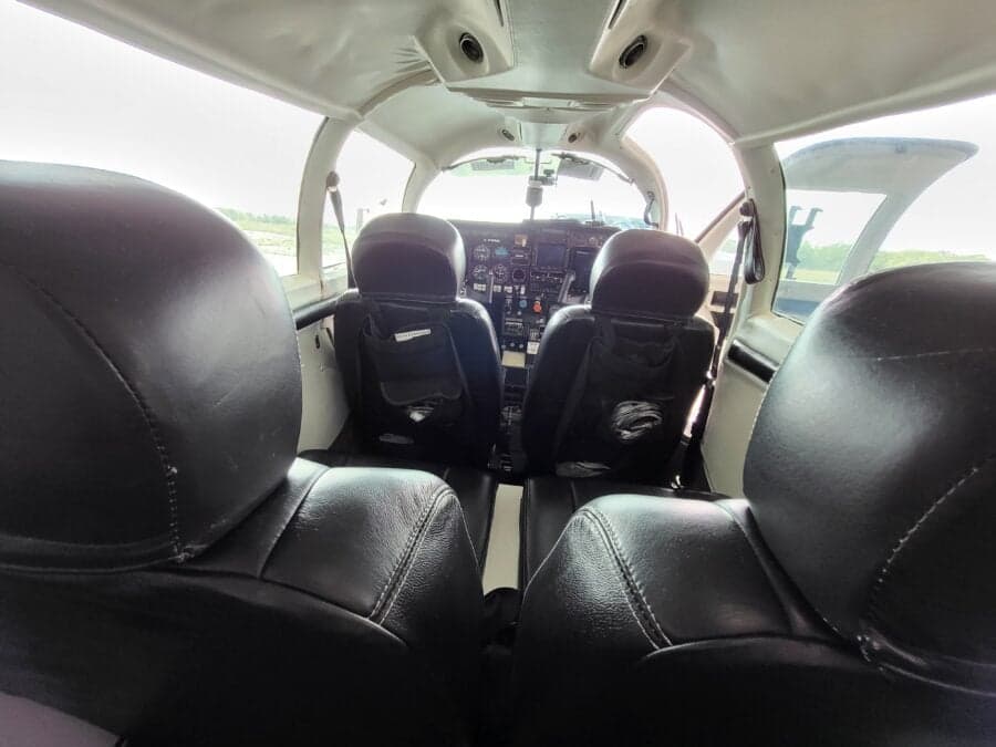 A view from the rear seats of a Mooney M20J cabin, looking forward towards the cockpit.