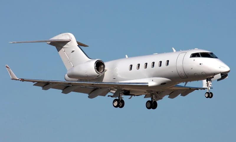 A Bombardier Challenger business jet in flight with landing gear down.