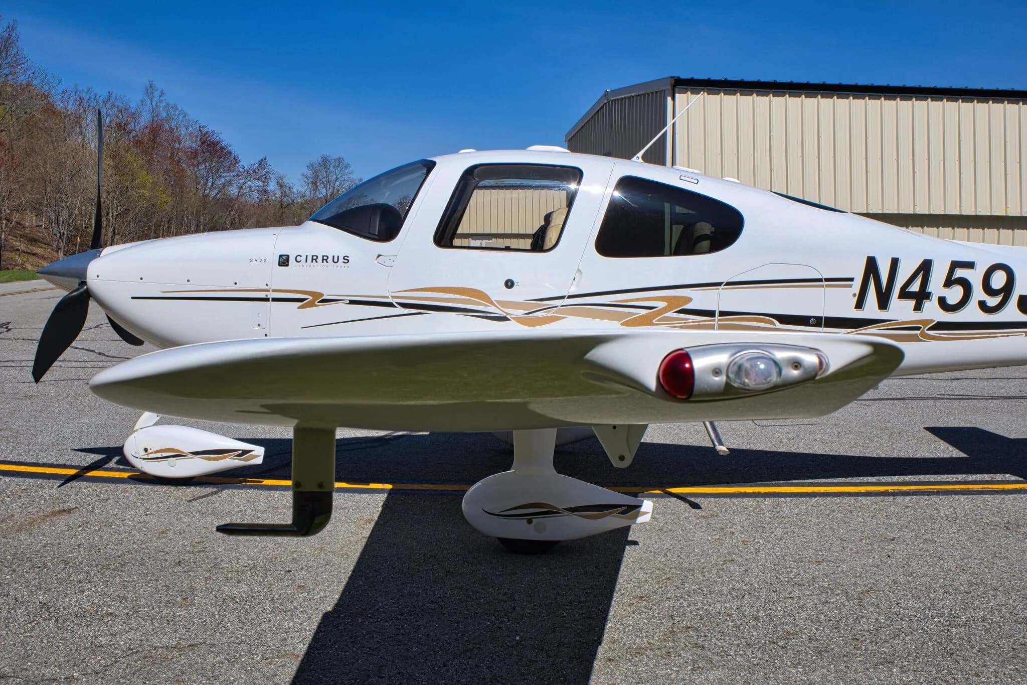 A close-up of the front fuselage and wing of the white Cirrus SR22 GTS Generation Three aircraft (N459J).