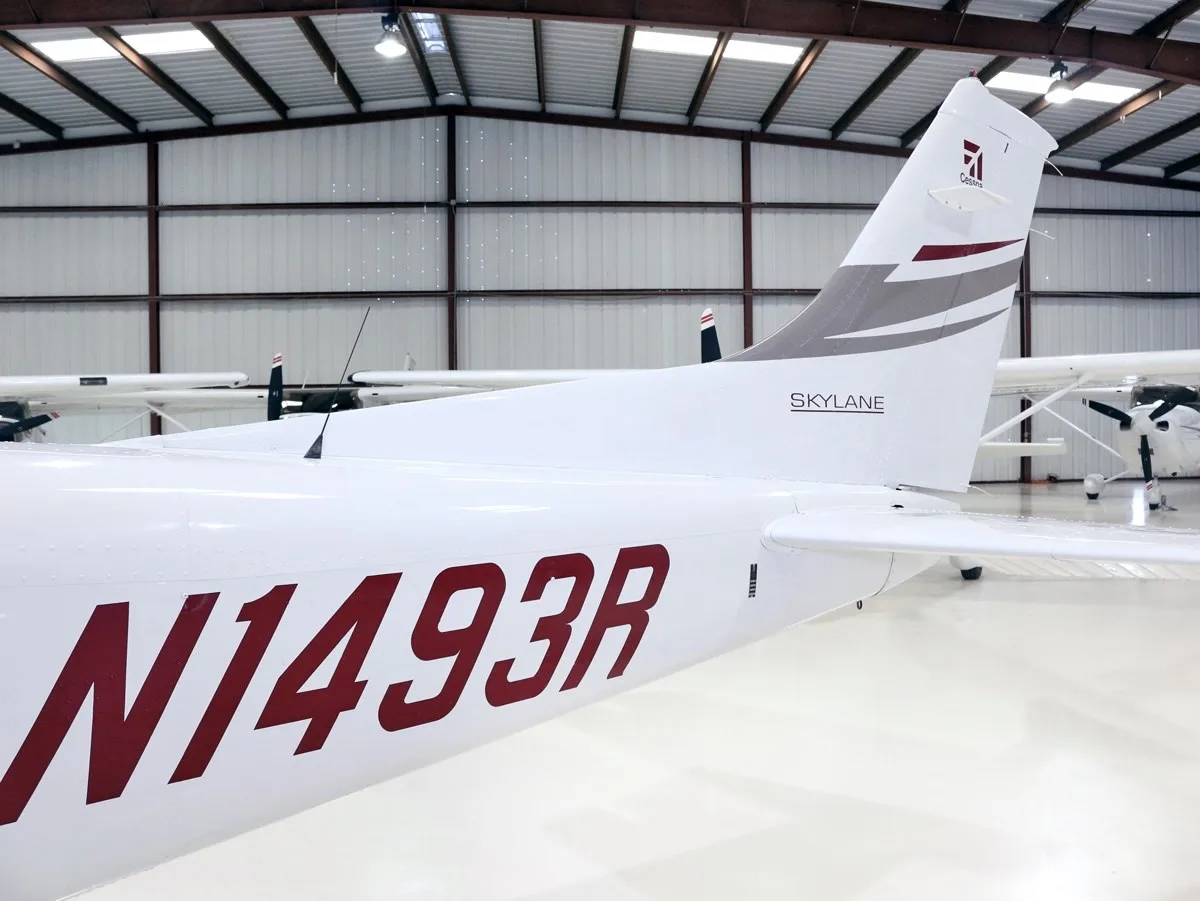 The tail section of the white Cessna Skylane N1493R, showing the registration and "SKYLANE" text.