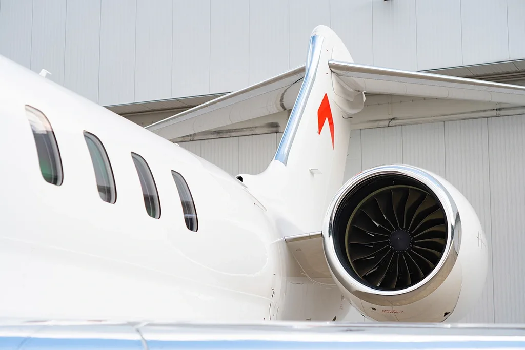 A close-up view of the tail and engine of a white Bombardier Global 7500 business jet.
