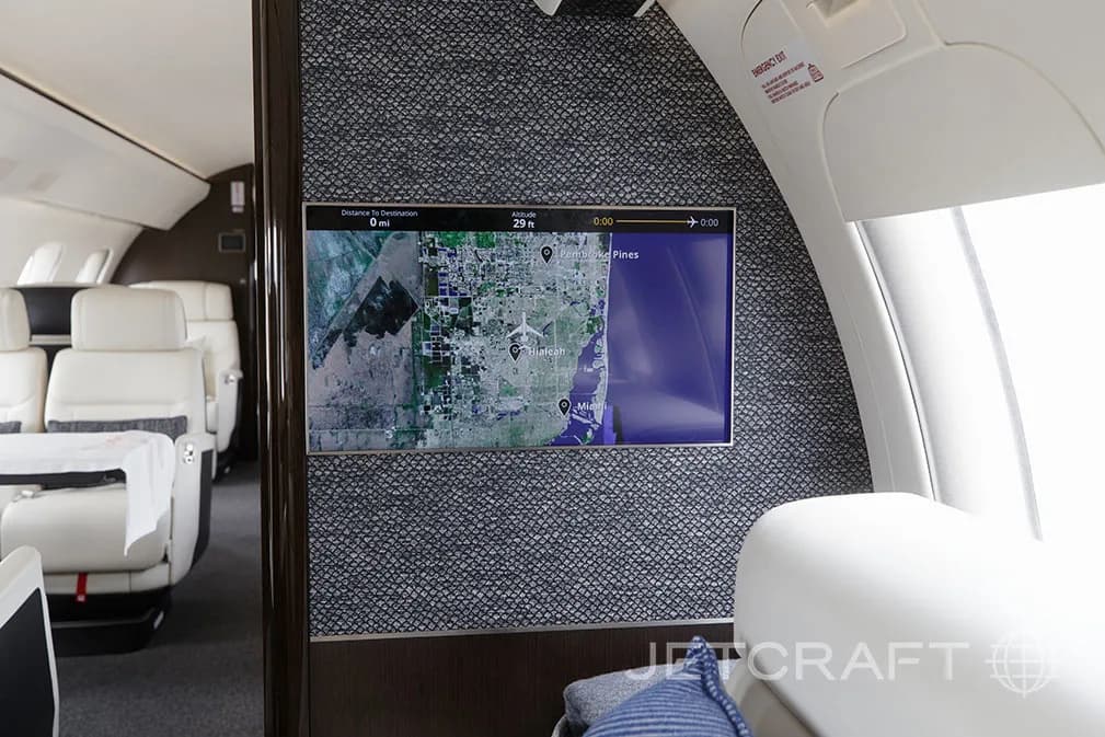 A large display screen showing a map in the luxurious cabin of a Bombardier Global 7500.