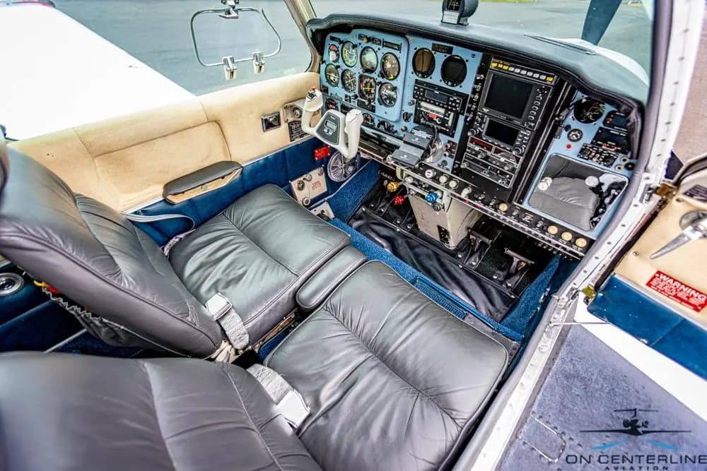 View of the cockpit with gray leather seats and instrument panel.