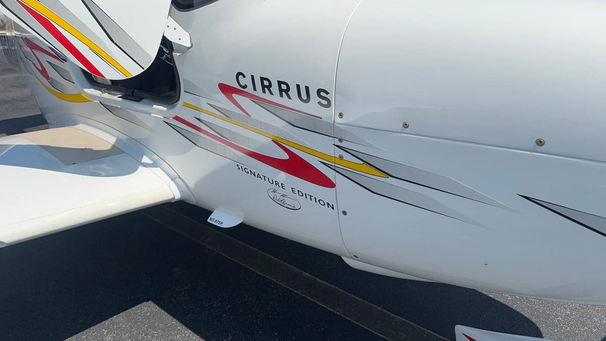 Close-up of the side of a Cirrus aircraft showing the Cirrus Signature Edition logo and custom graphics.