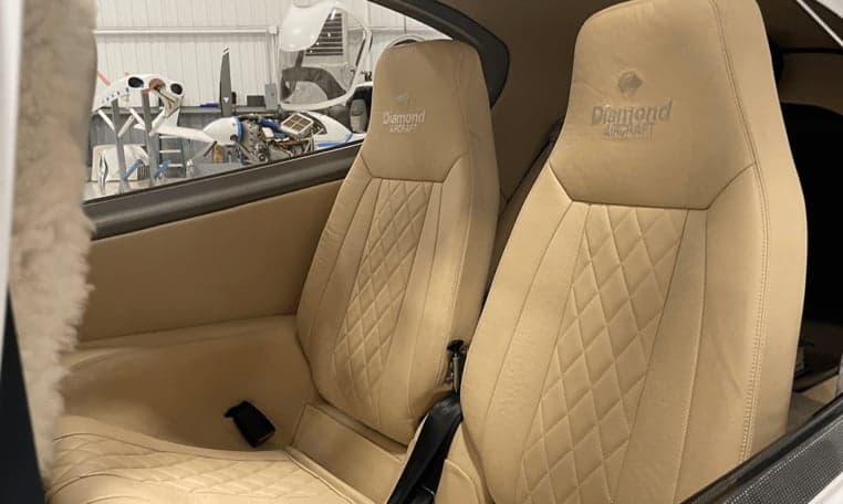 Beige leather seats with Diamond Aircraft logo inside the cabin.