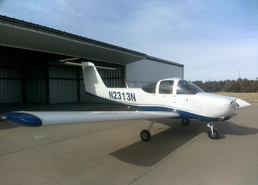 Side view of aircraft N2313N parked outside a hangar.