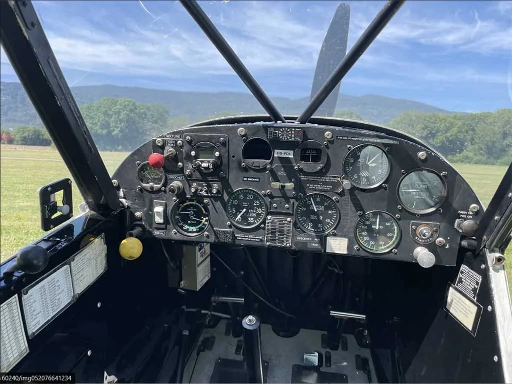 The black instrument panel of the aircraft, featuring various gauges, switches, and controls.
