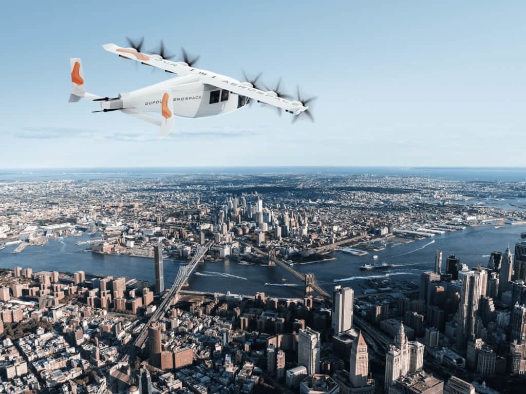 A Dufour Aerospace aircraft flying over a city.