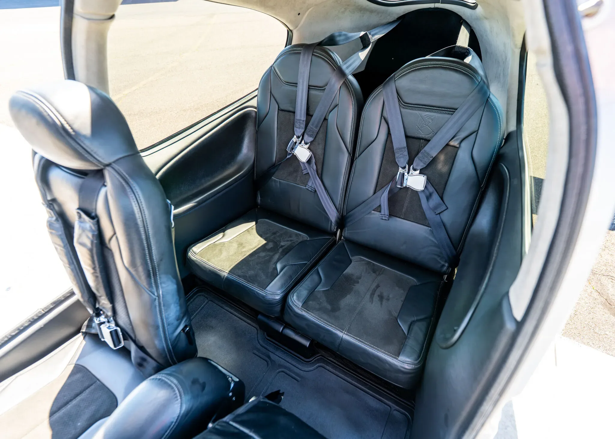 Overhead view of the black leather rear passenger seats inside the Cirrus SR22T aircraft cabin.