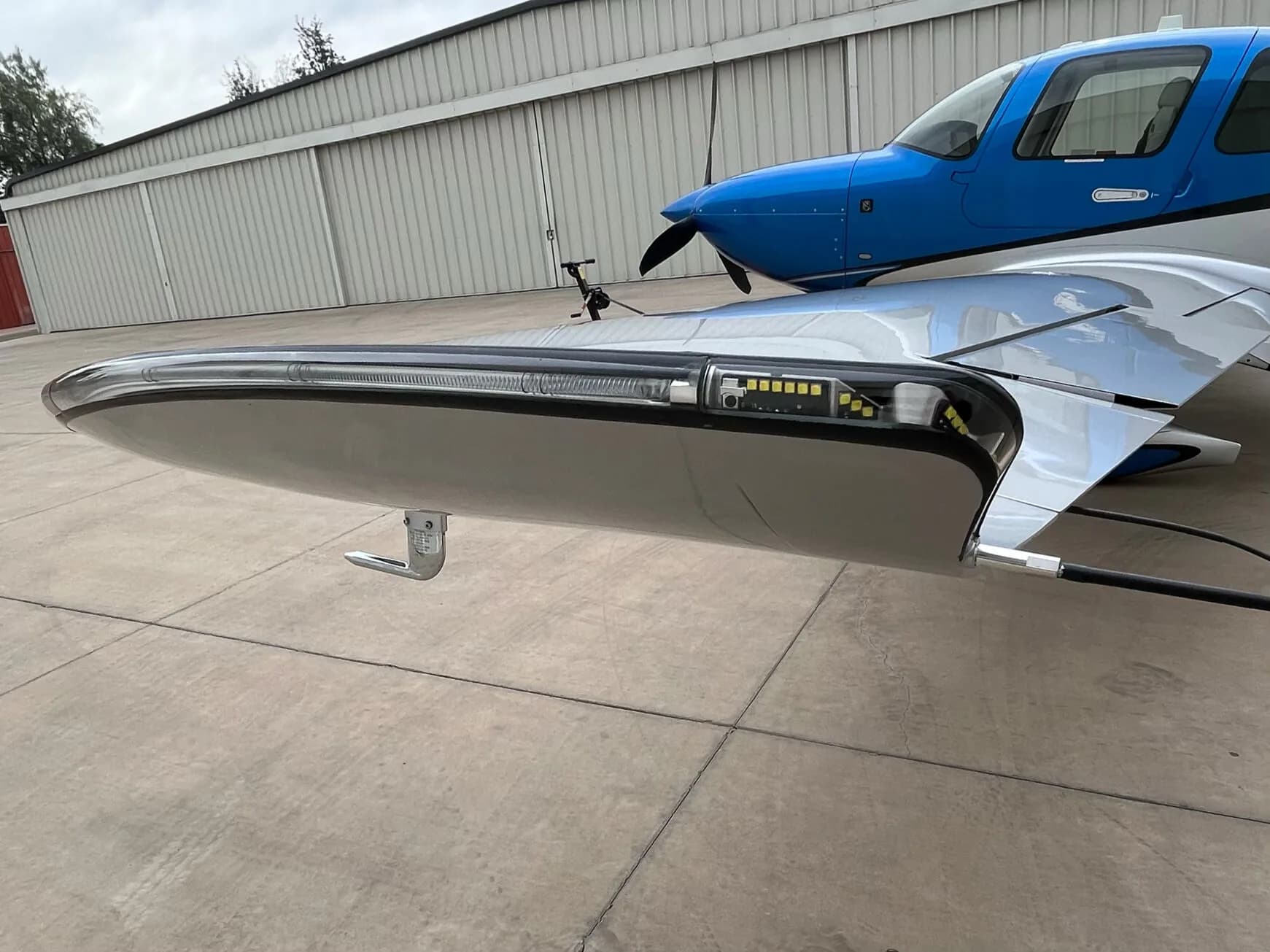 A close-up of the wingtip of the Cirrus SR22 GTS aircraft, showing the navigation and landing lights.