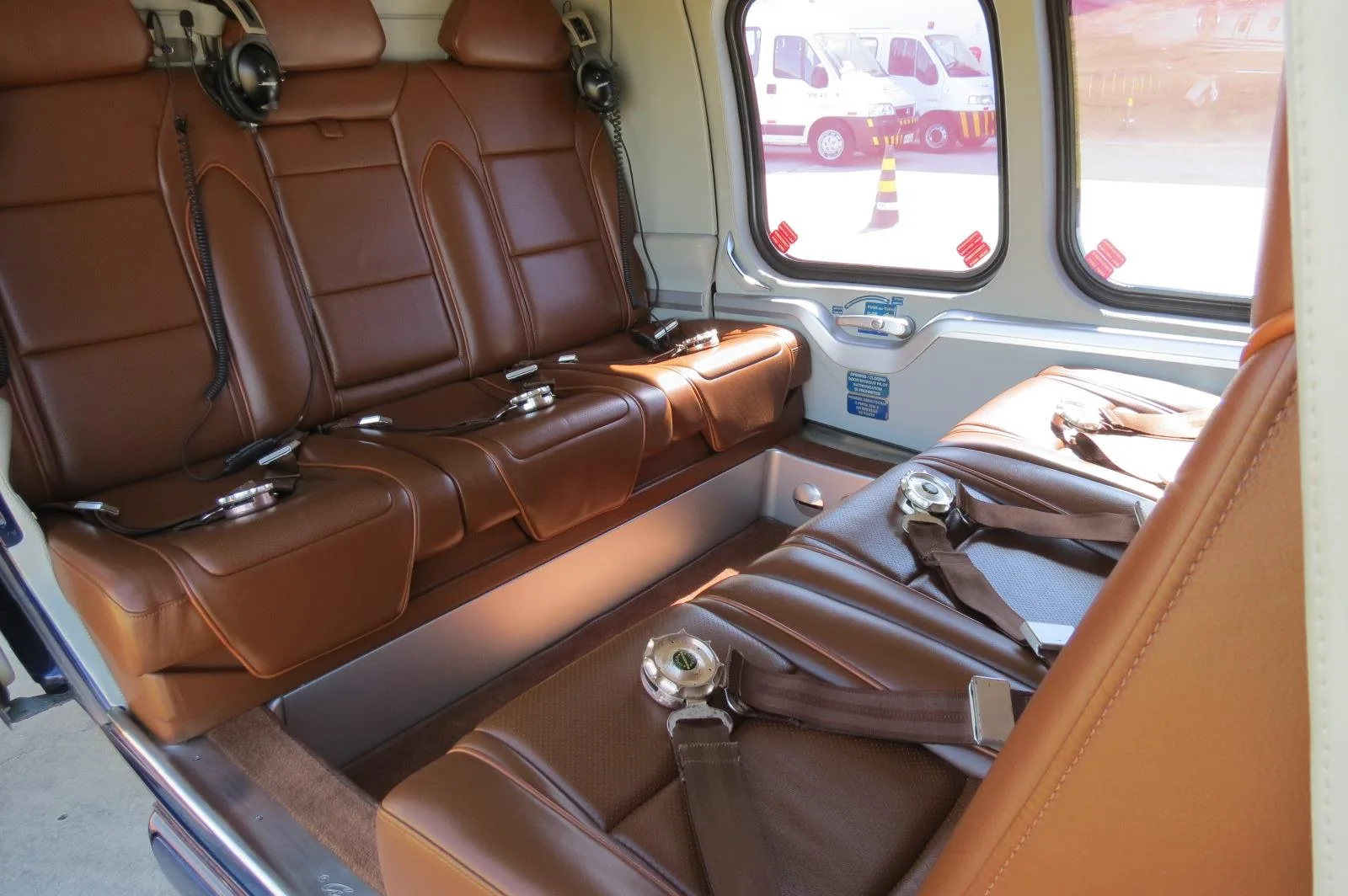 The interior of an AgustaWestland AW109 GrandNew helicopter, showing the brown leather seats.