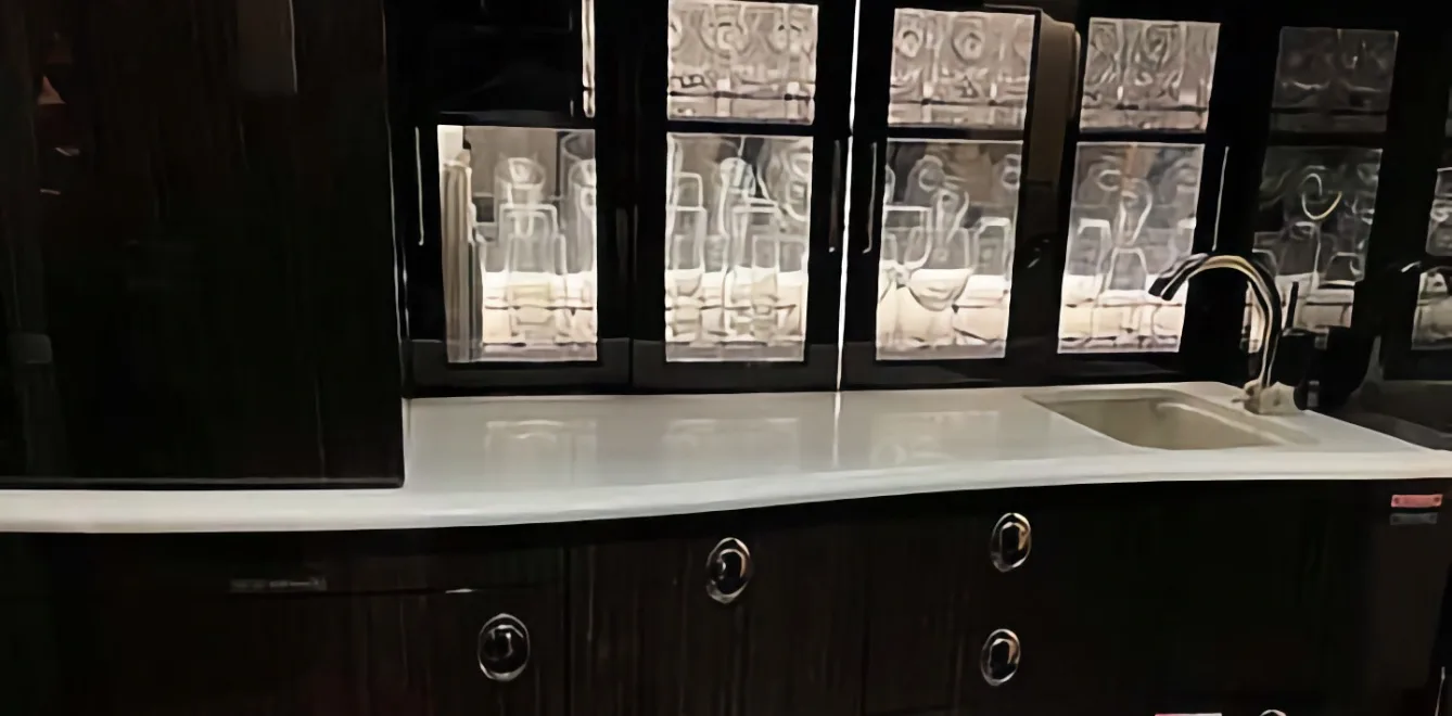 A dark wood cabinet with a white countertop and sink is shown.