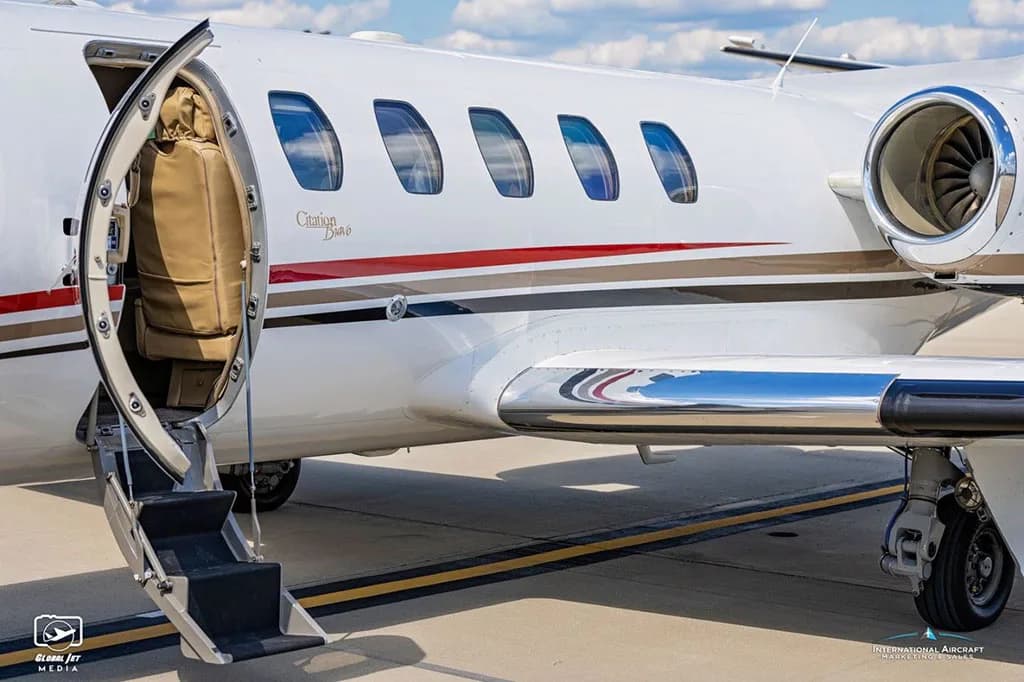 A close-up of the open passenger door and airstairs of a white Cessna Citation Bravo business jet.