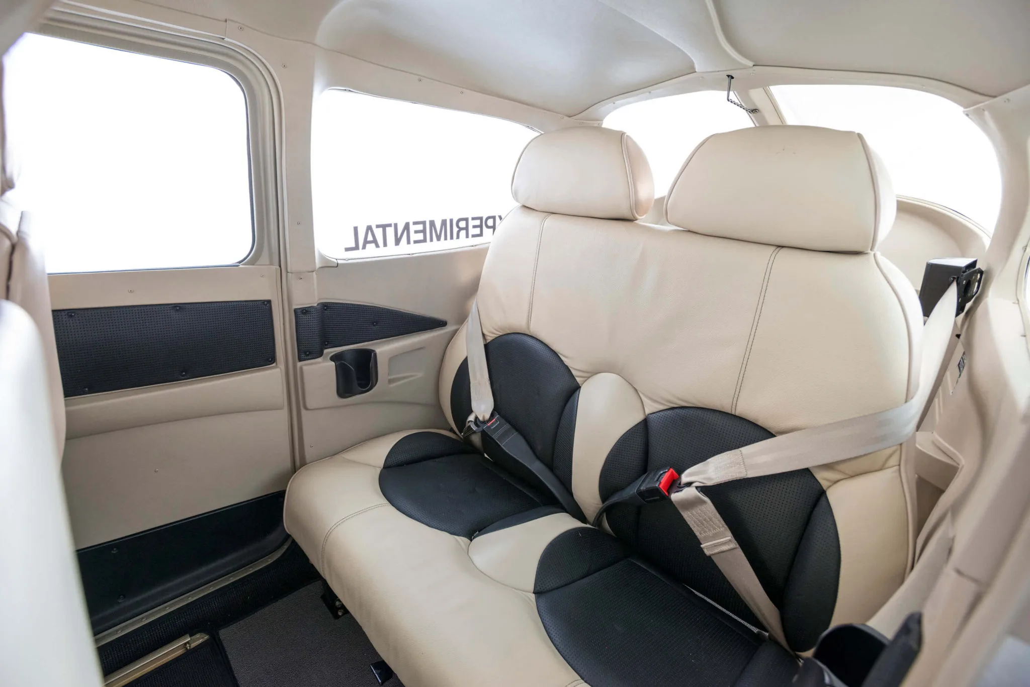 Rear seats of the aircraft with seatbelts visible.