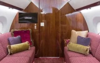 A seating area with couches and wood paneling inside the aircraft.
