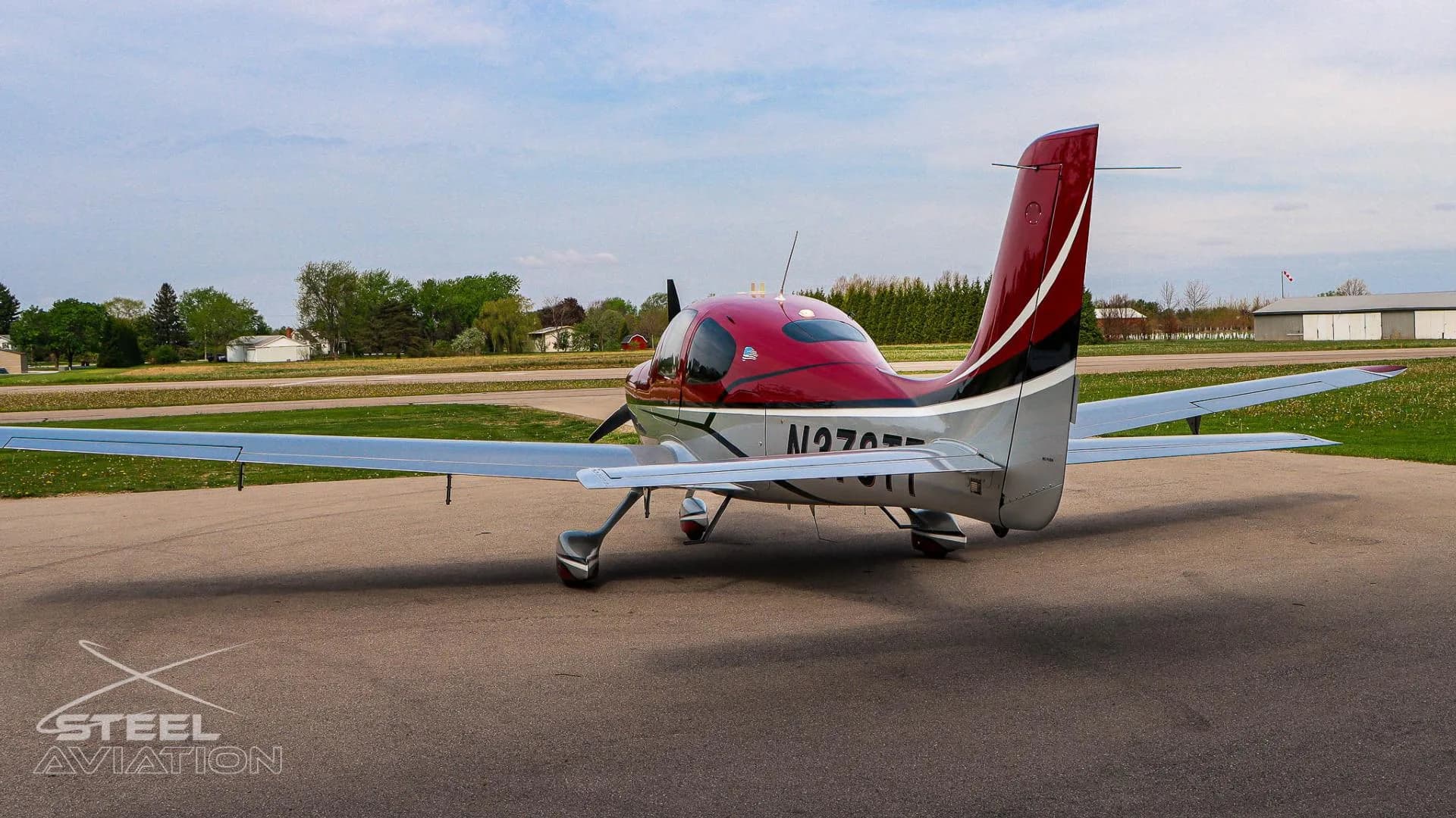 A red and white Cirrus SR22 aircraft with tail number N378TT is shown from the rear-left, highlighting the tail and left wing on an apron.