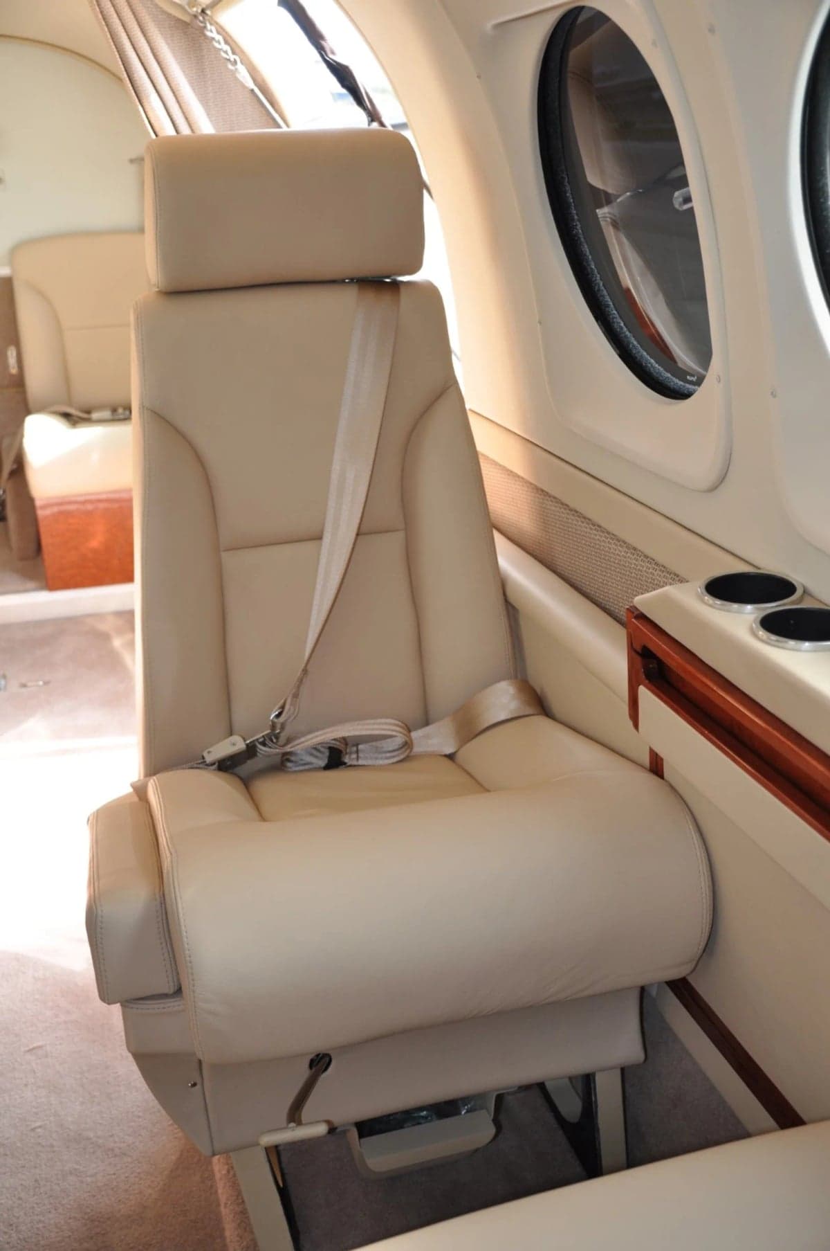 Close up of a cream-colored leather seat in the aircraft cabin.
