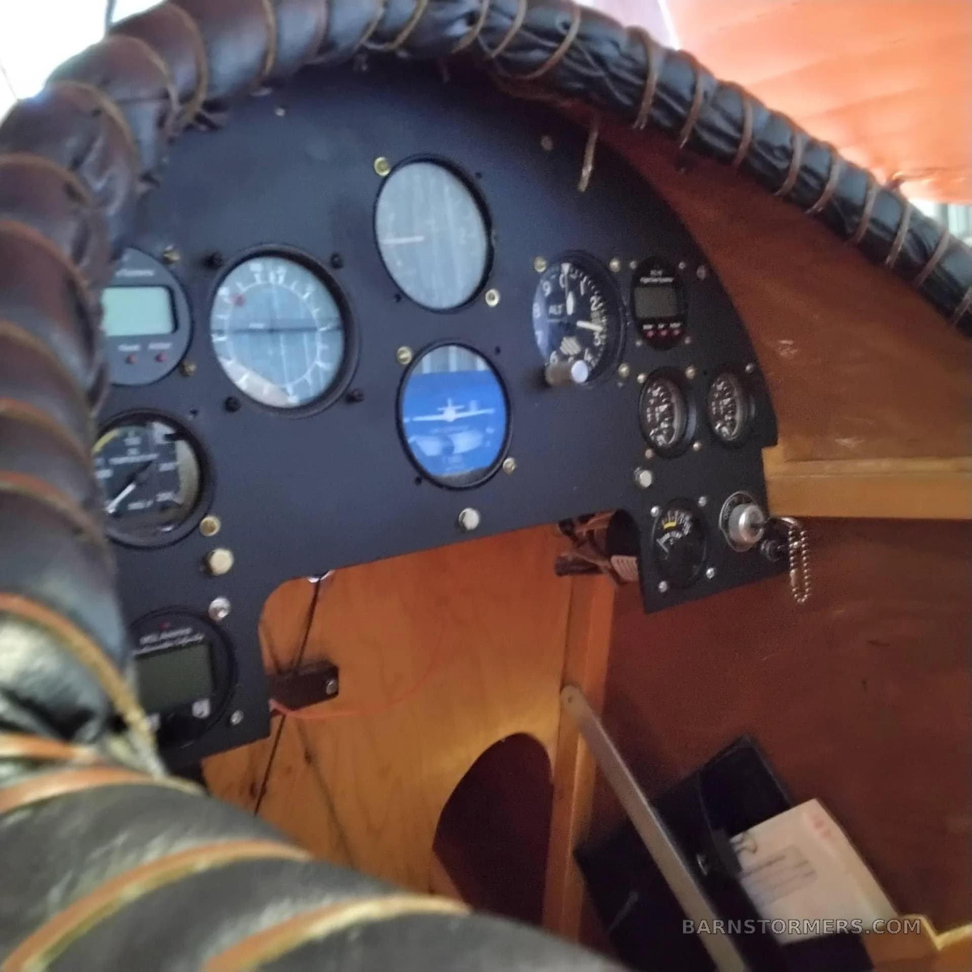 A close-up view of a vintage-style aircraft cockpit with a leather-wrapped control yoke and analog gauges.