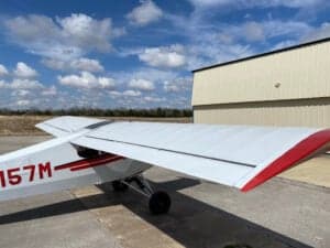 View of the wing and tail of a Piper Cub aircraft.