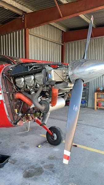 Close-up of the Cessna Skywagon 180's engine and propeller inside a hangar.