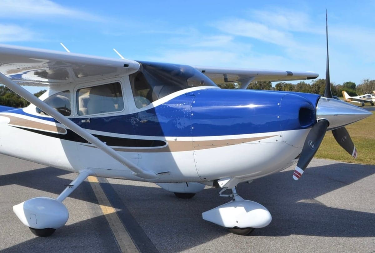 Close up of the front of a Cessna 182 Skylane with a blue and white paint scheme.