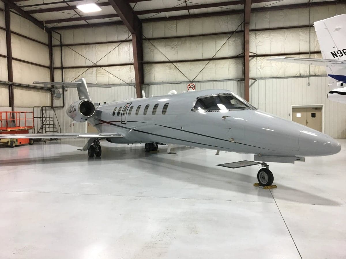 A gray aircraft, N800CH, is parked inside a hangar.