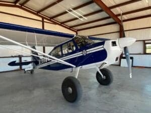 A blue and white ACA aircraft, registration N101BC, parked inside a hangar.
