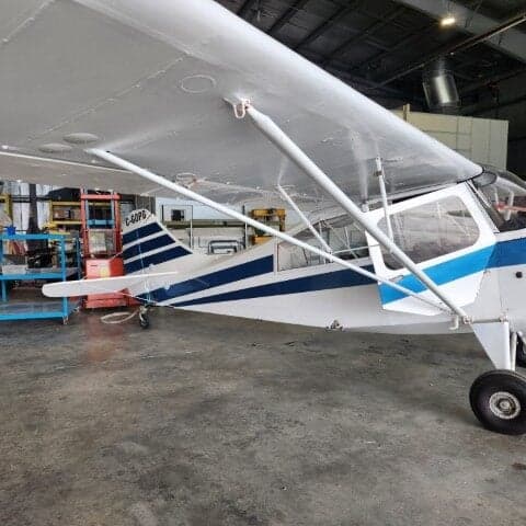 Tail section of a white and blue aircraft with registration C-GOPG.