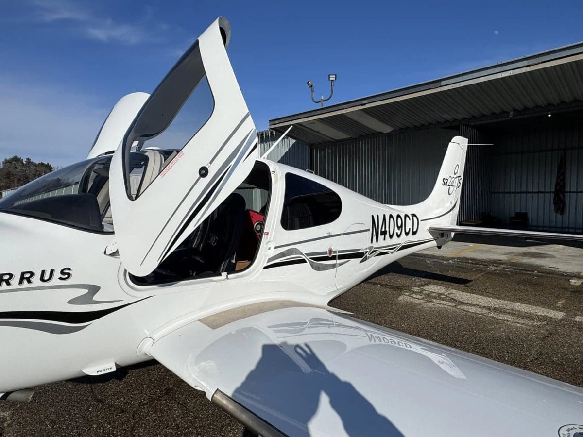 Side view of a Cirrus SR22T with open doors, showing the registration number N409CD.
