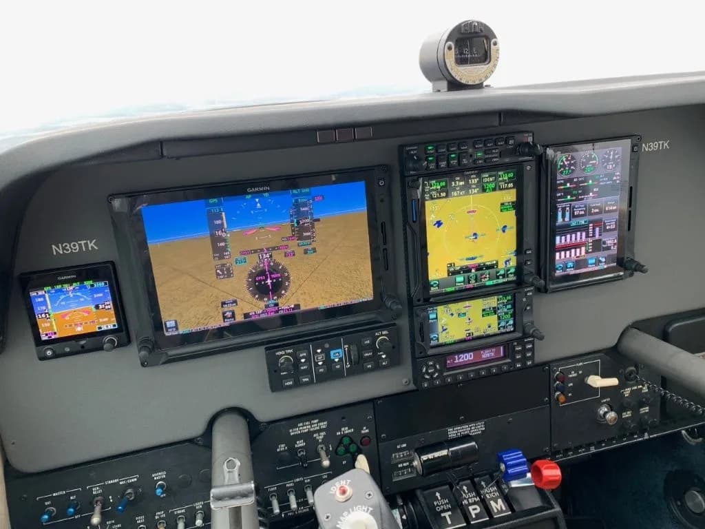 Close-up view of the modern glass cockpit with multiple Garmin displays and controls.