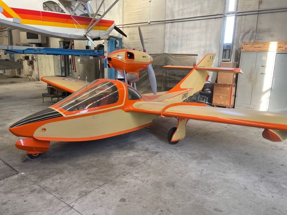 The I-PREY aircraft is shown in a hangar with an orange and cream paint scheme.