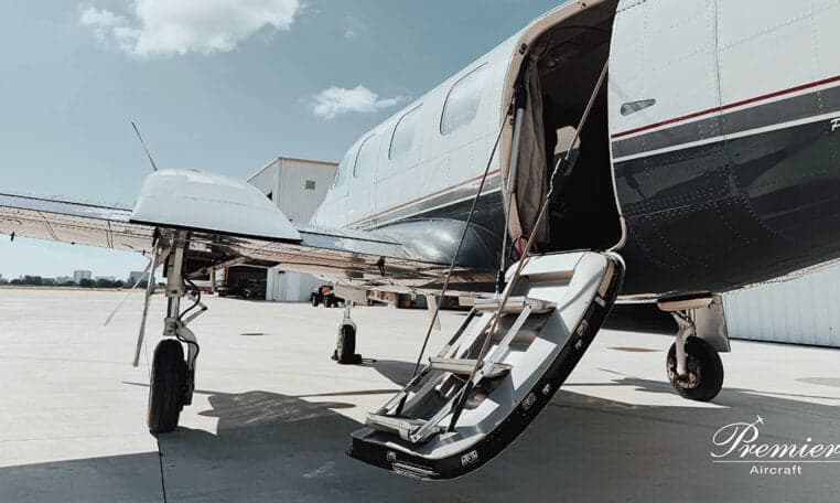 A twin-engine aircraft with the airstair door open.