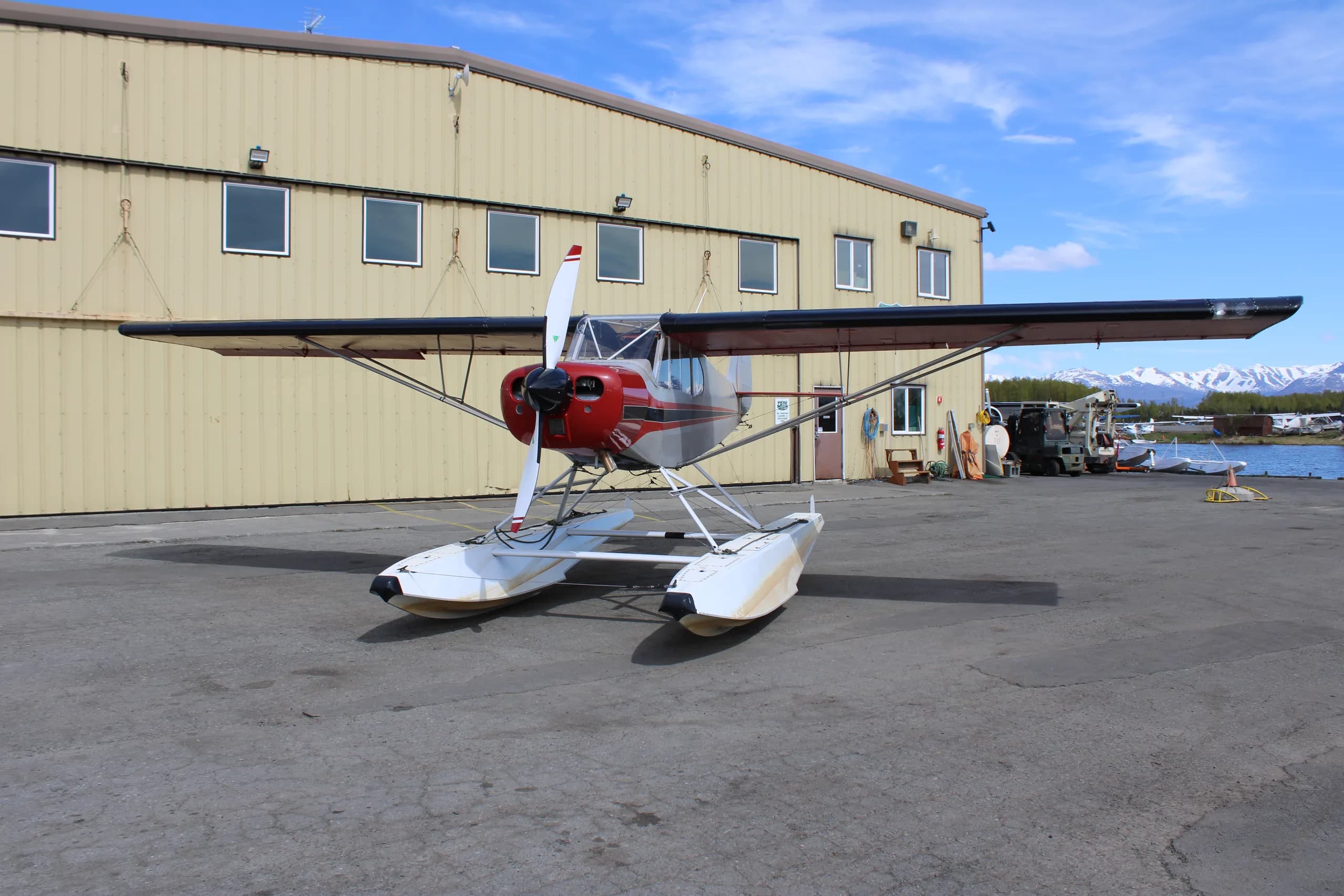 A red and silver float plane is parked on the tarmac.