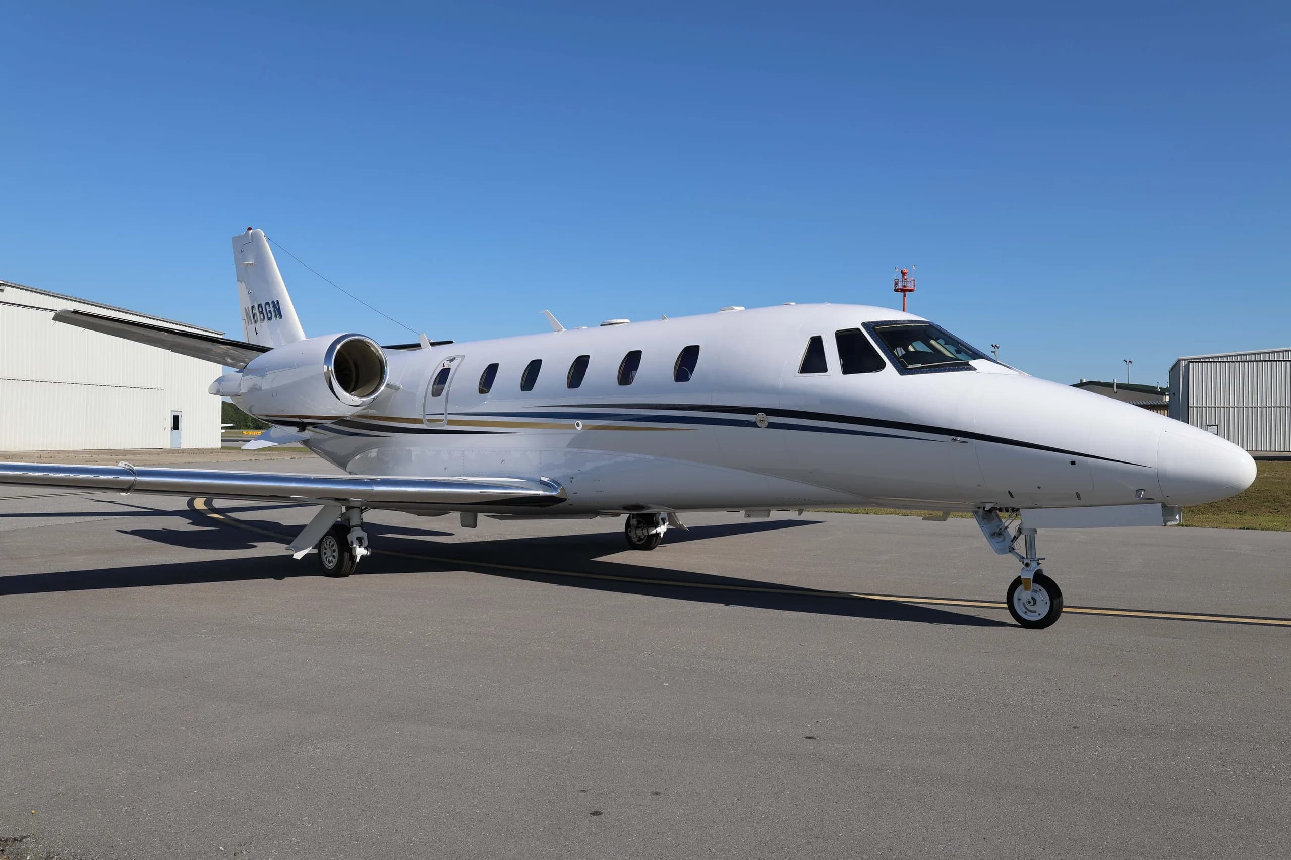 A white Cessna Citation business jet N68GN parked on an airport tarmac.