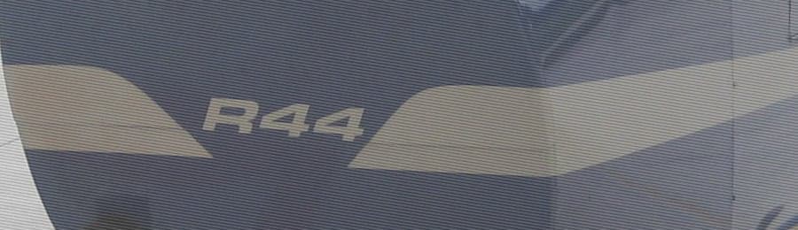 Close-up of the side of a helicopter with 'R44' markings.
