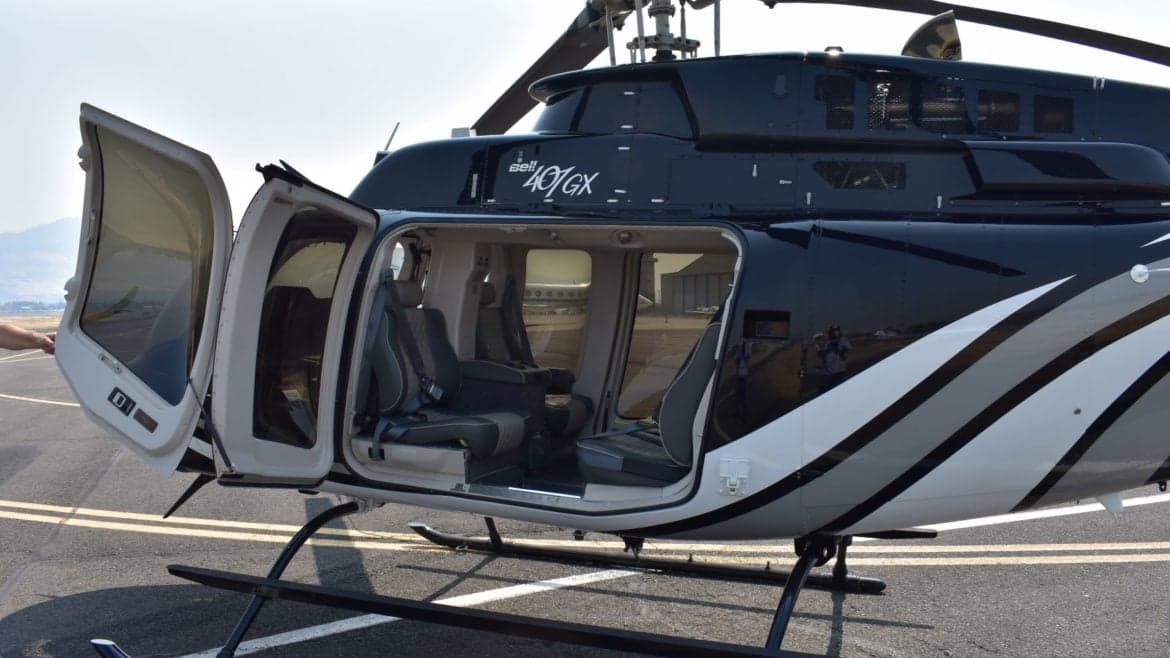 The open door of a Bell 407GX helicopter reveals the interior seating.