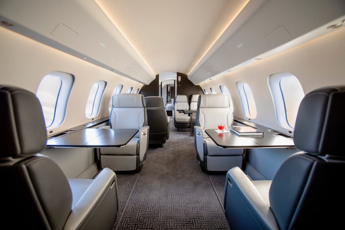 View of the aircraft interior with white leather seats and a table.