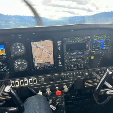The cockpit of an aircraft with a modern avionics suite is shown in flight.