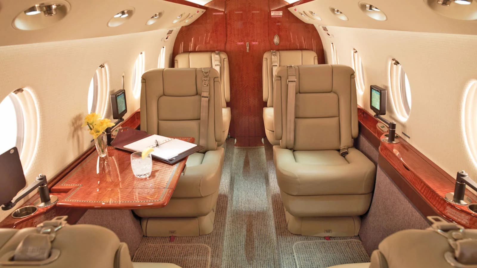 Interior view of the aircraft cabin with leather seats and wood trim.