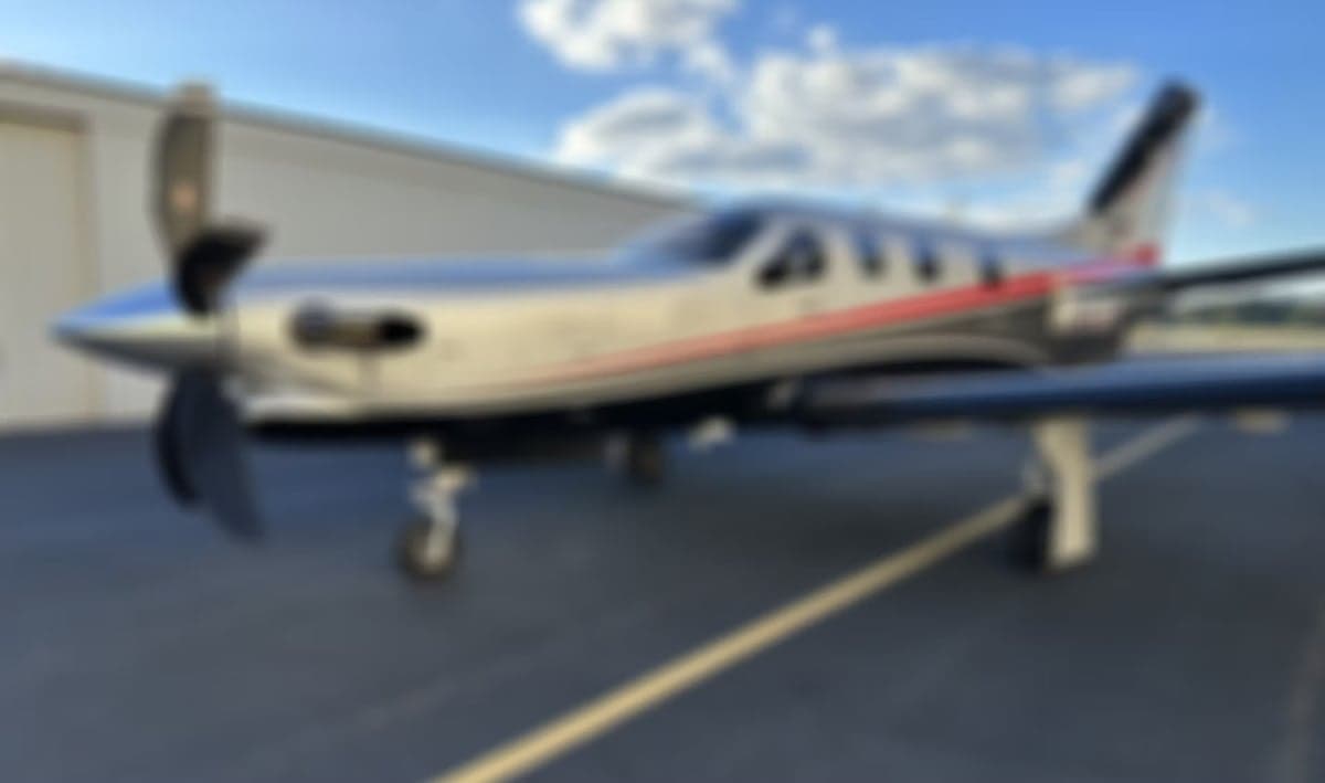A blurry image of a TBM 930 aircraft on the tarmac.
