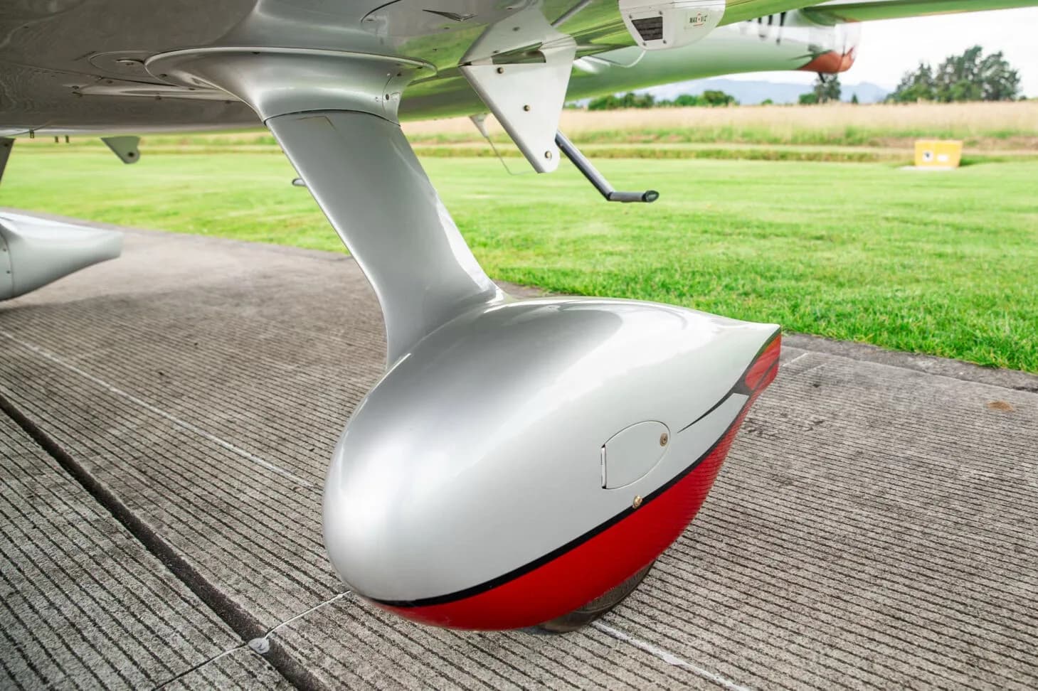 Close-up of the silver and red main landing gear fairing of the Cirrus SR22T aircraft.