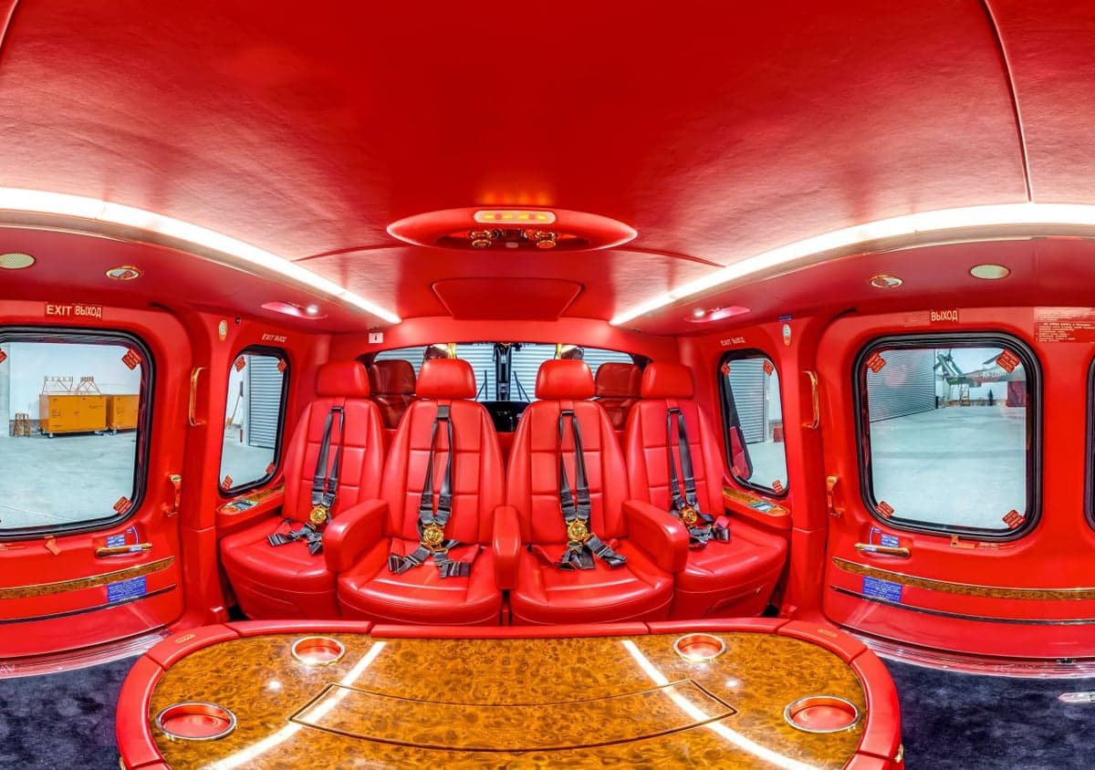 The helicopter's red leather interior features four seats and a table.